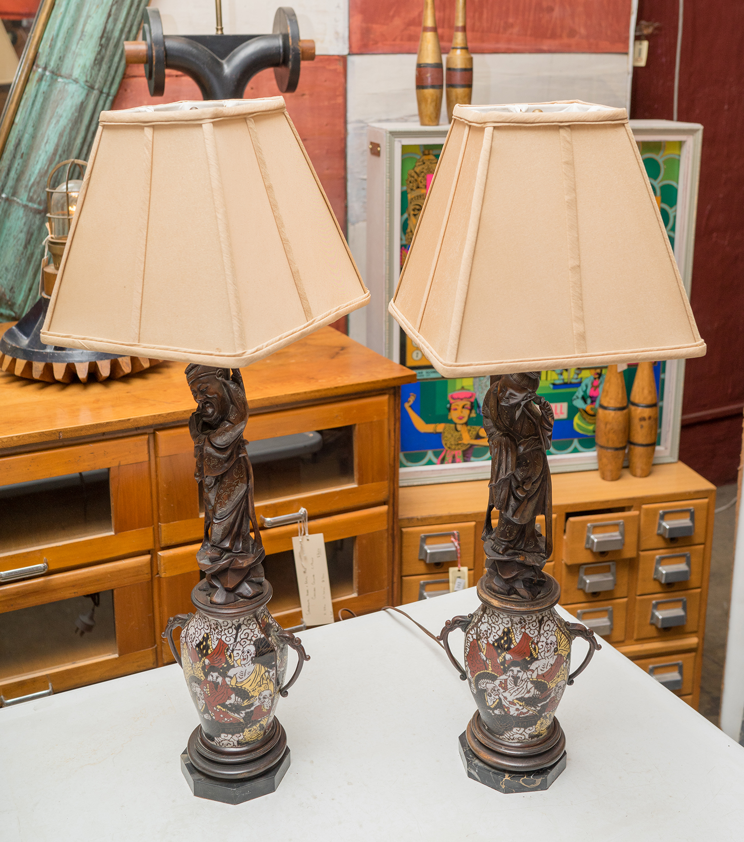 Appraisal: A PAIR OF DECORATIVE ORIENTAL BEDSIDE LAMPS Carved oriental figure