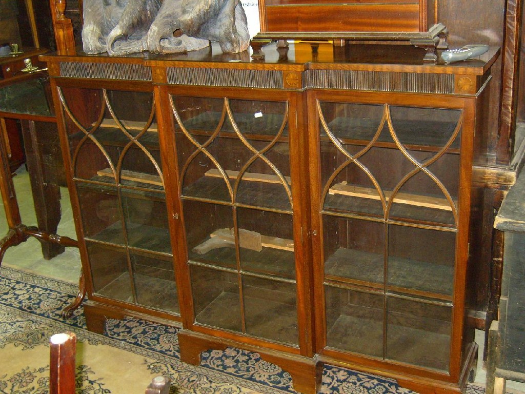 Appraisal: An Edwardian mahogany breakfront display cabinet enclosed by glazed panelled