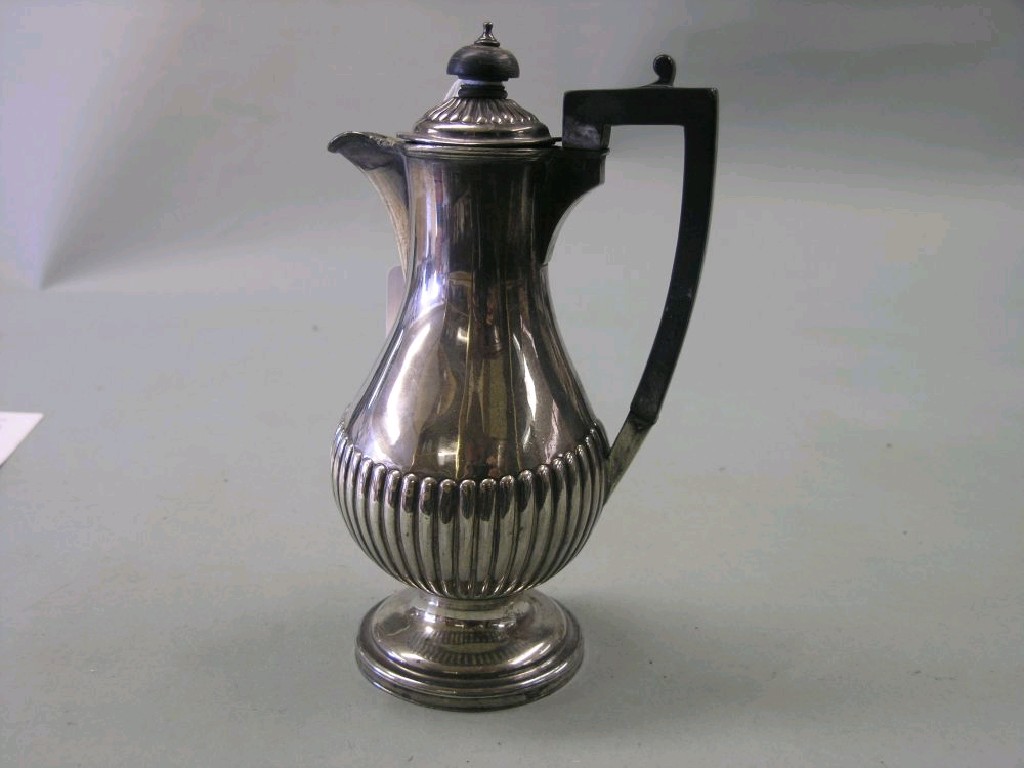 Appraisal: A silver half-reeded hot water jug with hinged cover and