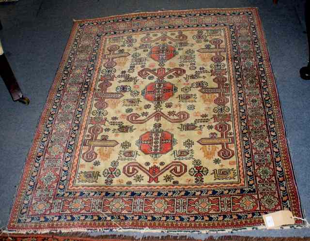 Appraisal: AN ANTIQUE CAUCASIAN DESIGN RUG with three geometric medallions on