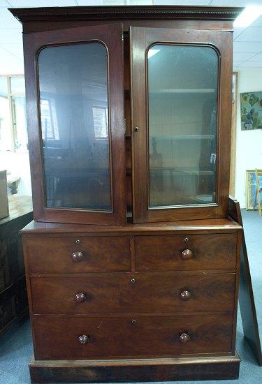 Appraisal: A Victorian mahogany bookcase the dentil cornice over two arched