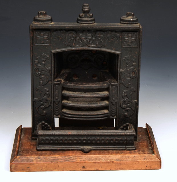 Appraisal: A VICTORIAN MINIATURE CAST IRON FIREPLACE AND SURROUND on a