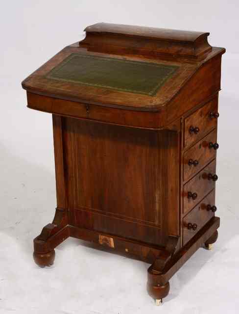 Appraisal: A VICTORIAN WALNUT DAVENPORT with green leather inset lifting lid