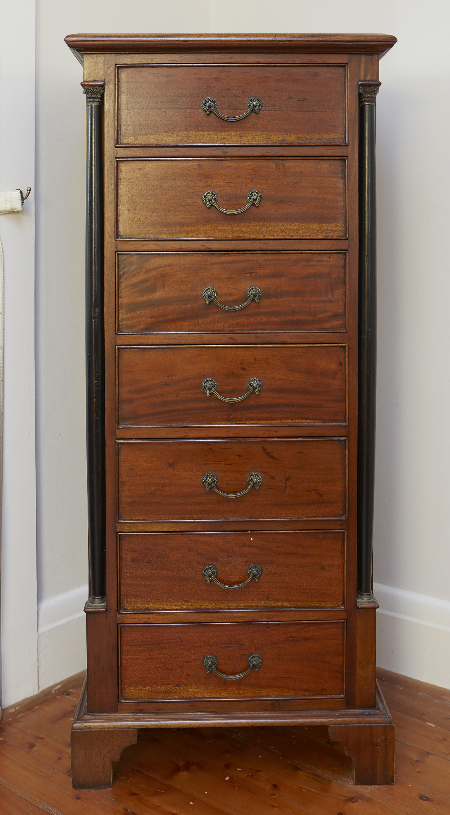 Appraisal: A REGENCY STYLE WELLINGTON CHEST With black stained corinthian column