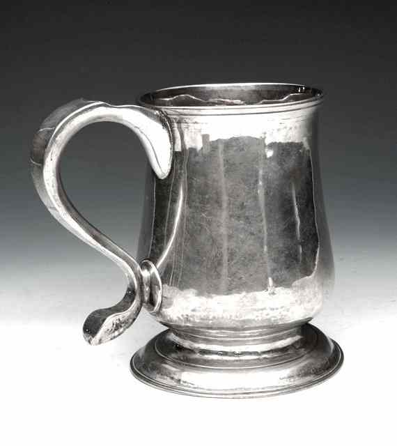 Appraisal: A GEORGE III SILVER BALUSTER SHAPED TANKARD with a scroll