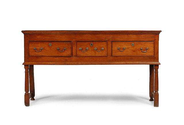 Appraisal: A GEORGE III FRUITWOOD DRESSER BASE fitted with three drawers