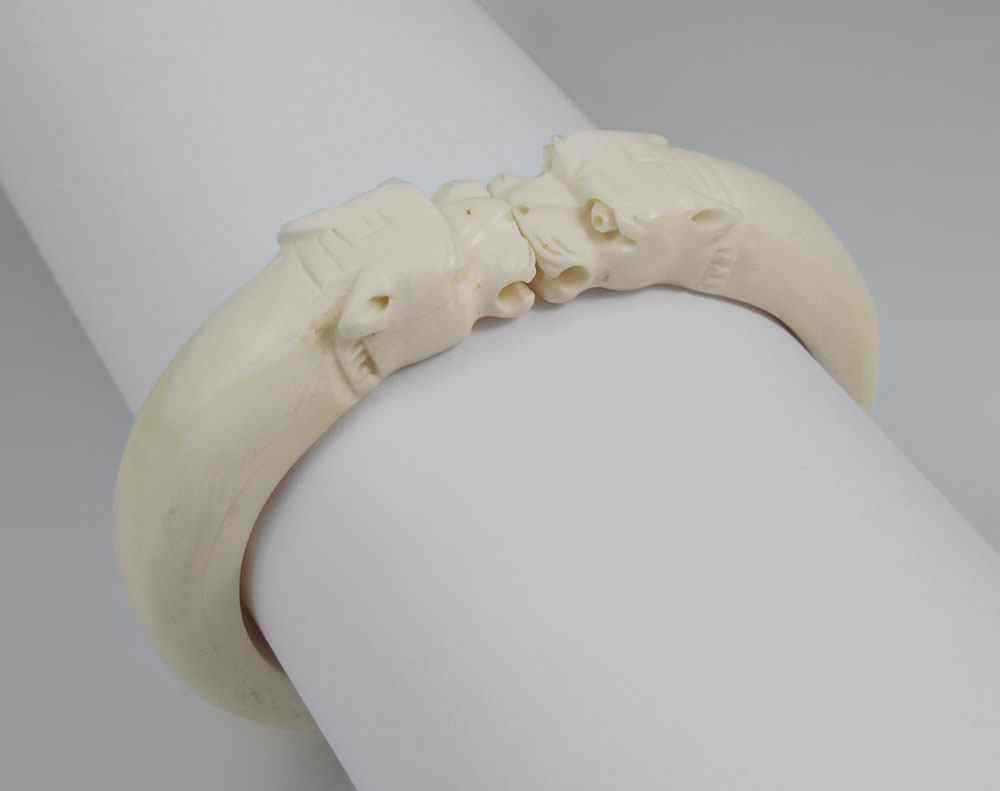 Appraisal: CARVED IVORY HINGED BANGLE BRACELET Twin dogs '' overall interior