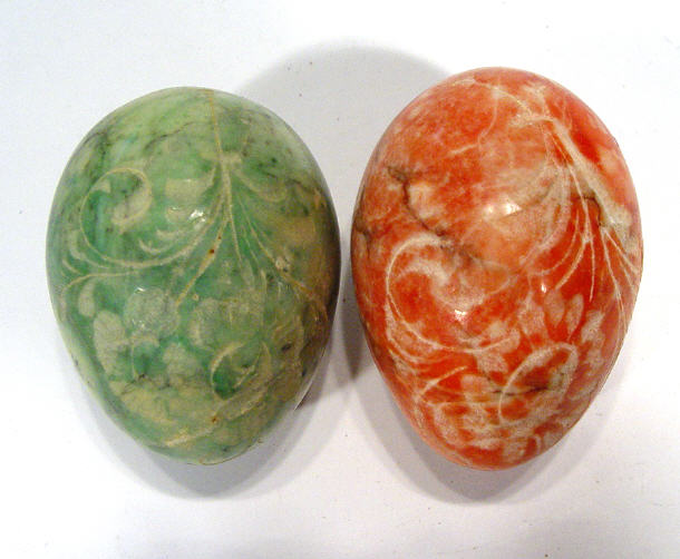 Appraisal: Two red and green marble eggs engraved with stylised leaves