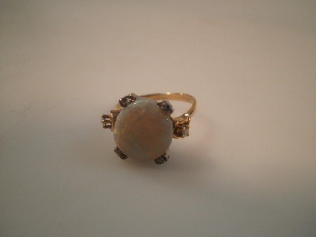 Appraisal: A cabochon opal ring set with tiny diamonds to the