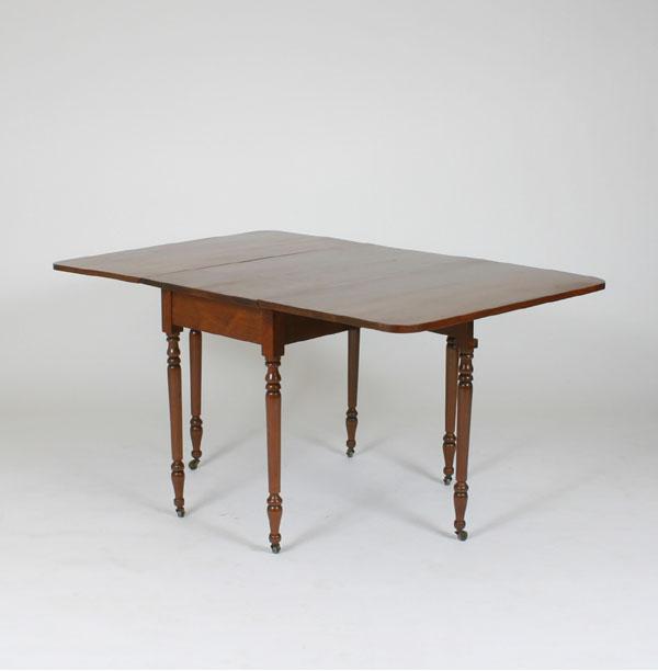 Appraisal: Cherry drop leaf table th C turned legs brass casters