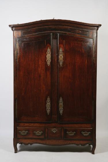 Appraisal: A FRENCH PROVINCIAL ARMOIRE with an arch and moulded cornice