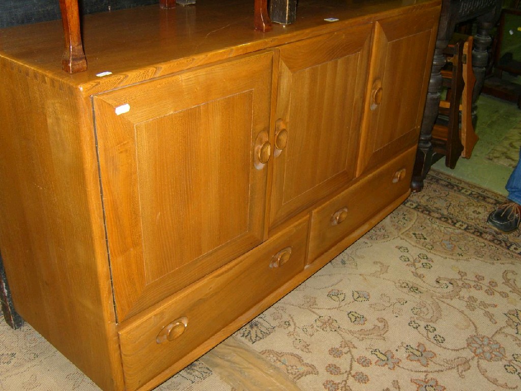 Appraisal: An Ercol style elm sideboard fitted with an arrangement of