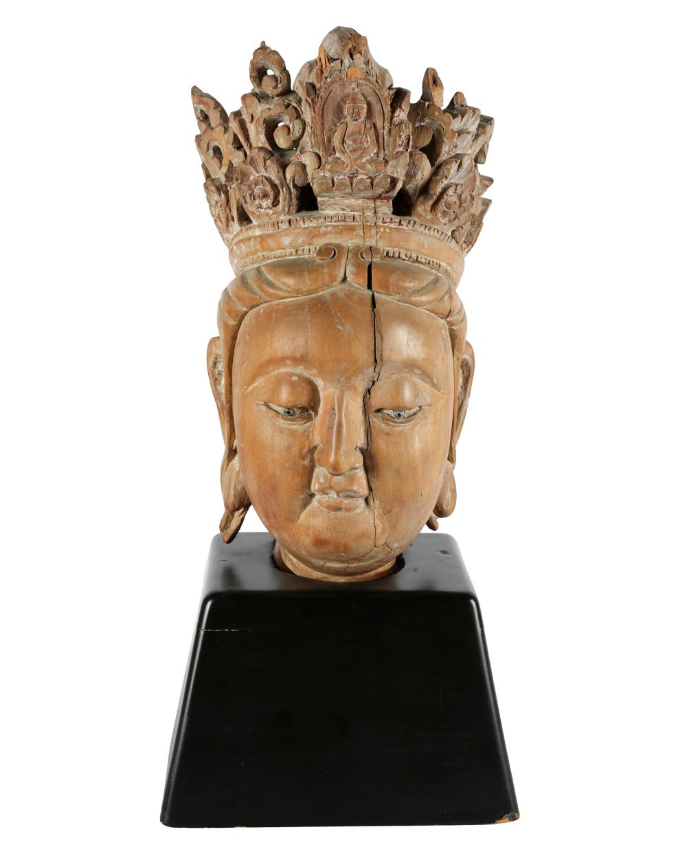 Appraisal: CARVED WOOD HEAD OF BUDDHAaffixed to a wooden base Provenance