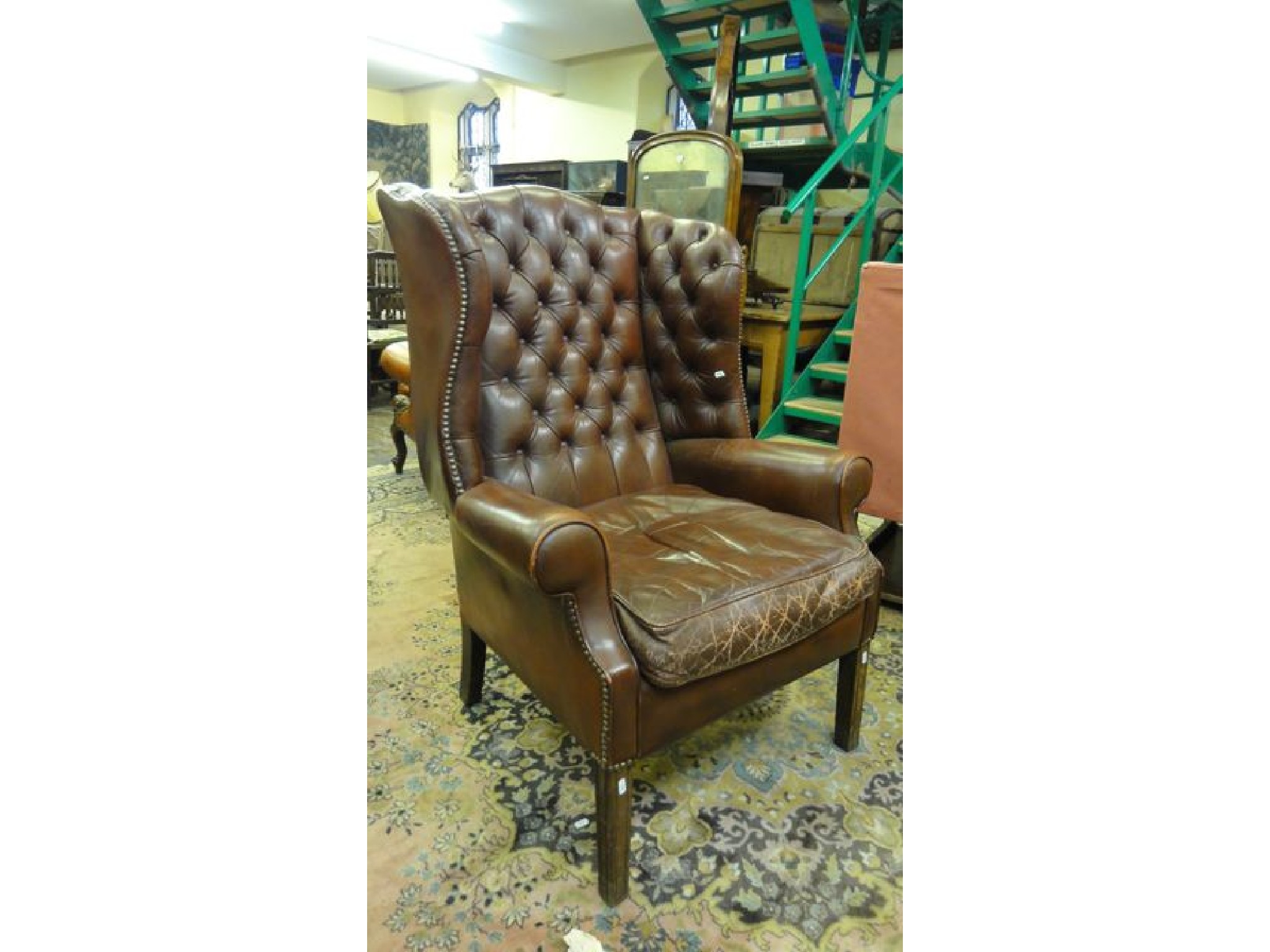 Appraisal: A Georgian style wing chair upholstered in brown leather with