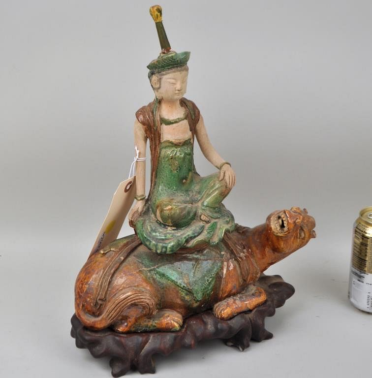 Appraisal: Tang Dynasty Pottery Seated Deity Astride Dragon with carved stand