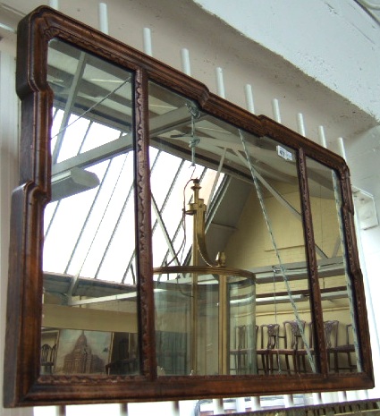 Appraisal: An th century walnut framed triple section wall mirror with