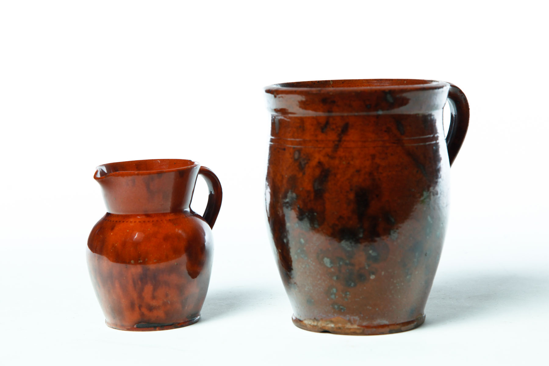 Appraisal: TWO REDWARE PITCHERS American nd half- th century Applied handles