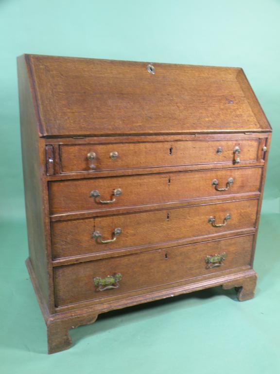 Appraisal: A George III oak bureau the hinged fall enclosing drawers