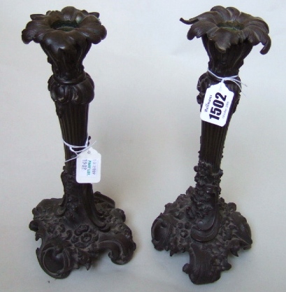 Appraisal: A pair of patinated bronze candlesticks of Rococo design the