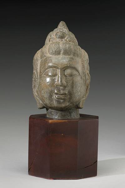 Appraisal: A grey stone head of a Buddhist attendant Carved in