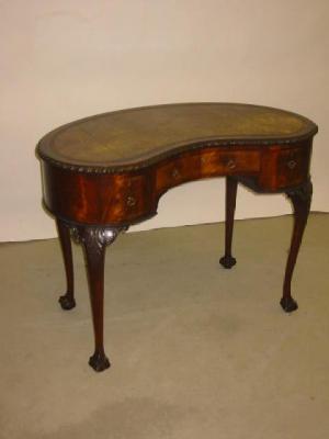 Appraisal: A MAHOGANY WRITING TABLE of kidney form the banded leather