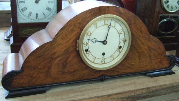 Appraisal: A walnut and ebonised cloud shape mantel clock early th