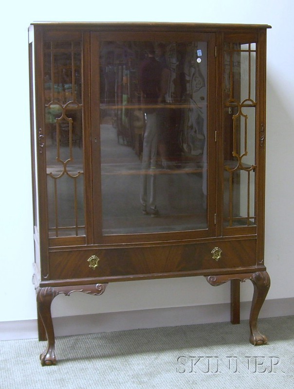 Appraisal: Chippendale-style Carved Mahogany Swell-front China Cabinet with Paw Feet the