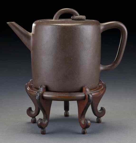 Appraisal: Chinese Qing Yixing clay teapot with a free ring on