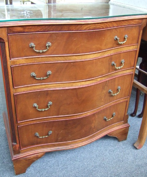 Appraisal: A reproduction mid th century style mahogany serpentine chest of