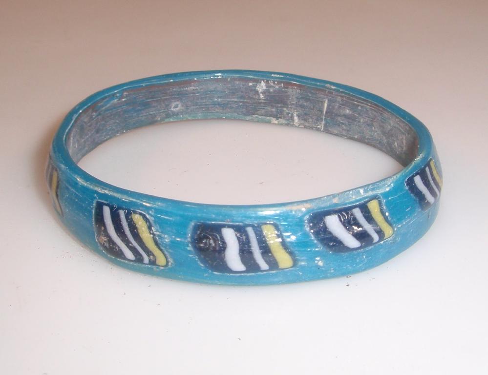 Appraisal: An opaque turquoise glass bangle decorated with applied mosaic glass