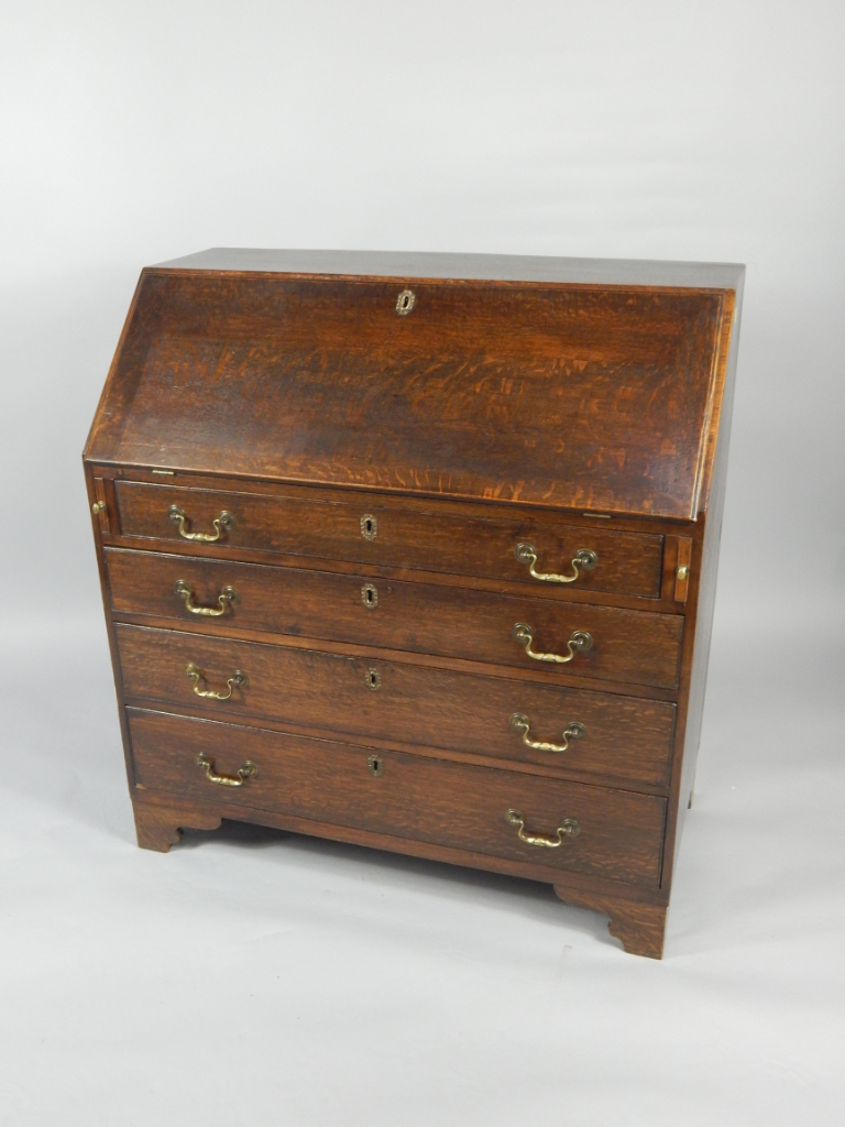 Appraisal: A George III oak bureau the fall flap opening to