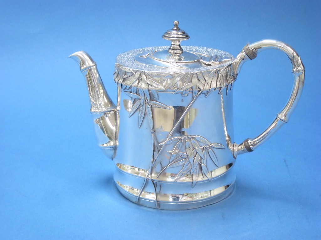 Appraisal: A Chinese silver cylindrical Teapot with leafage decoration and simulated