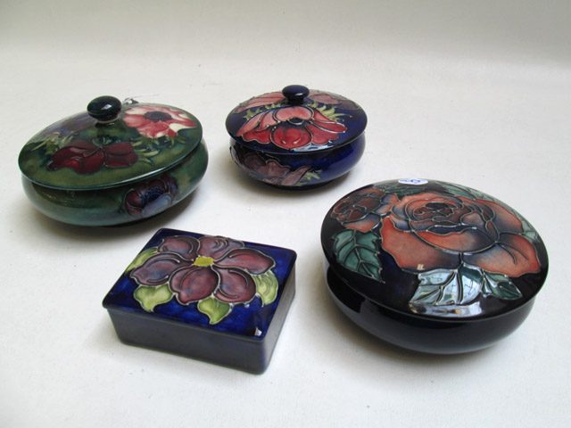 Appraisal: FOUR MOORCROFT POTTERY LIDDED VESSELS hand painted under glaze with