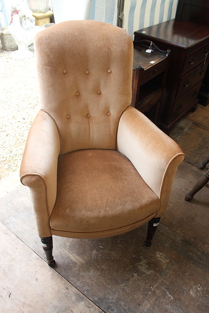 Appraisal: A TH CENTURY BUTTONED AND UPHOLSTERED ARMCHAIR with turned tapering