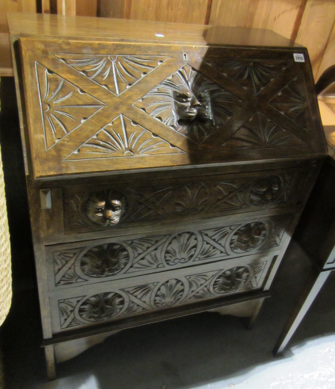 Appraisal: A th century oak bureau with lion carved handles