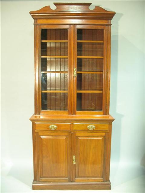 Appraisal: COLONIAL WALNUT BOOKCASE th century the broken cornice above two