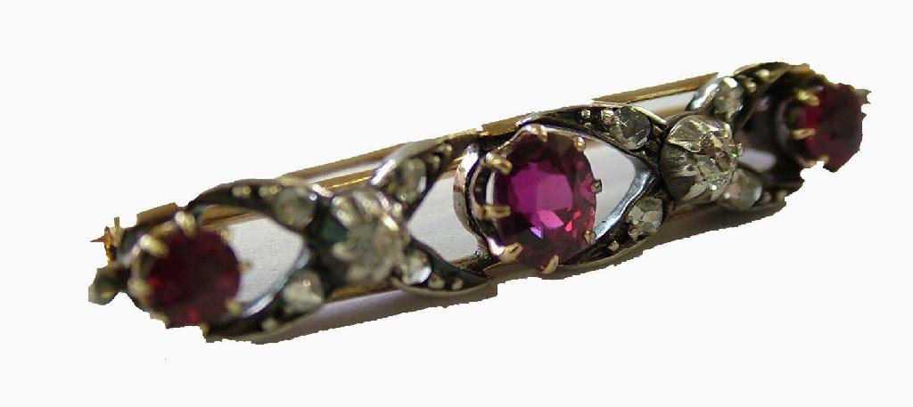 Appraisal: Attractive ruby and diamond bar brooch with crossover design yellow