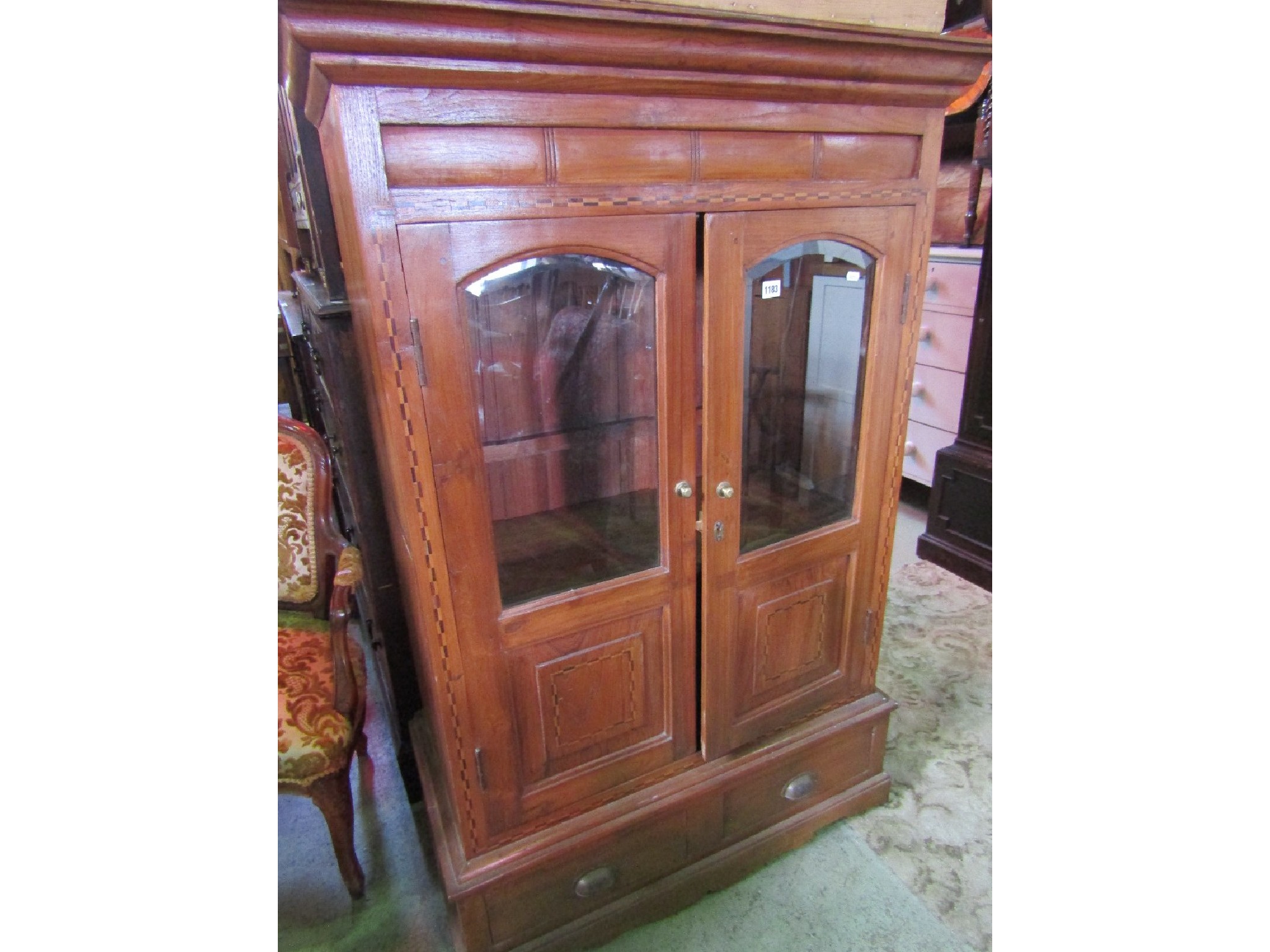 Appraisal: A hardwood freestanding side cabinet with chequered inlay detail enclosed