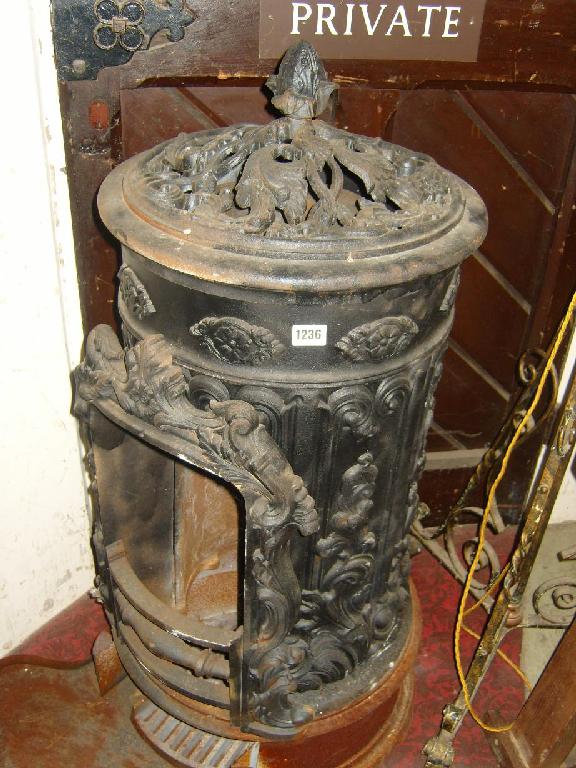 Appraisal: A cast iron wood burning stove with profuse relief and