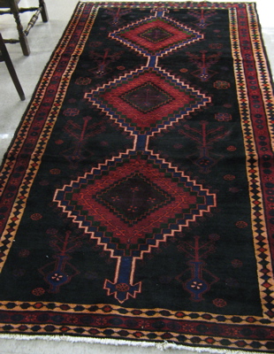 Appraisal: PERSIAN TRIBAL CARPET three geometric medallion design on black ground