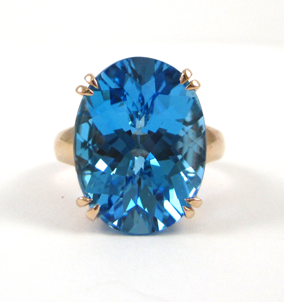 Appraisal: FOURTEEN KARAT ROSE GOLD AND TOPAZ RING oval checkerboard-cut blue