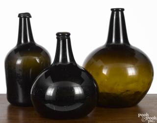 Appraisal: Three early olive amber glass bottles th c '' h