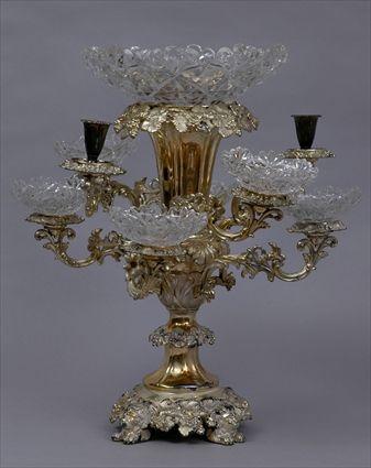 Appraisal: ENGLISH SILVER-PLATED TWO-LIGHT EPERGNE WITH CUT GLASS DISHES The leaf-tiered