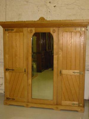 Appraisal: A VICTORIAN GOTHIC REVIVAL ASH TRIPLE WARDROBE with brass strapwork