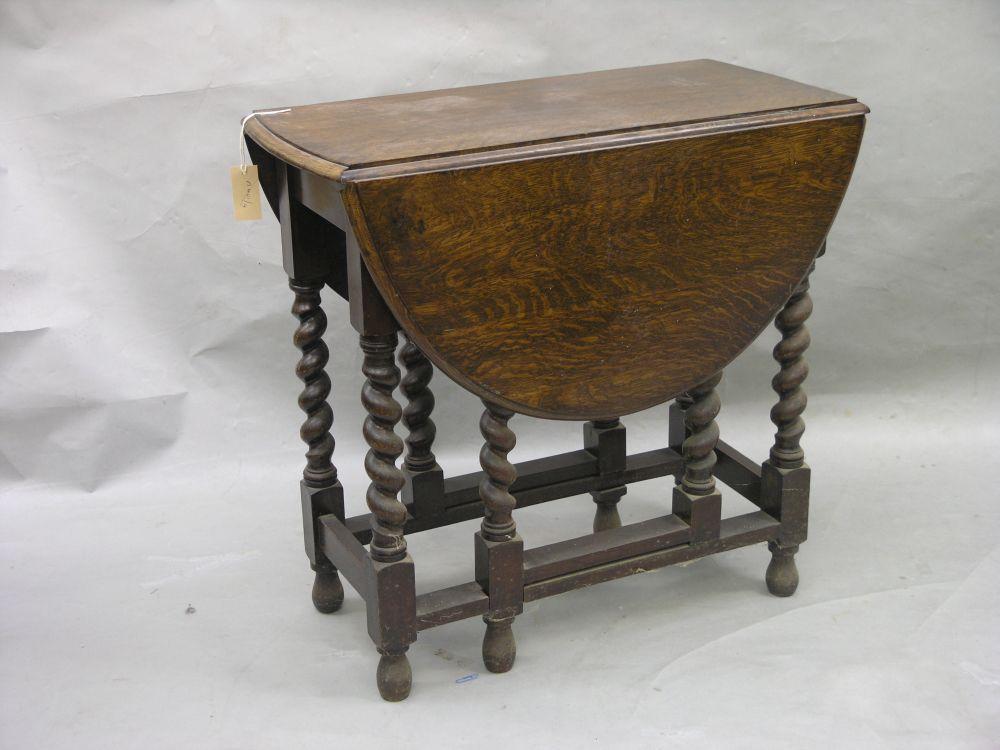 Appraisal: A solid dark oak gateleg table on barley twist underframe