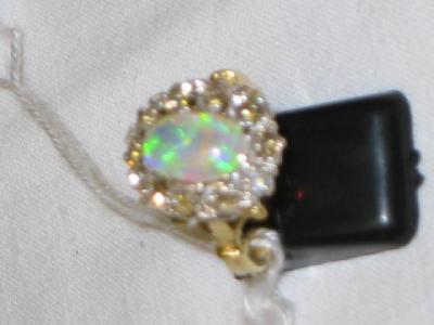 Appraisal: AN OPAL AND DIAMOND CLUSTER RING with oval fire opal