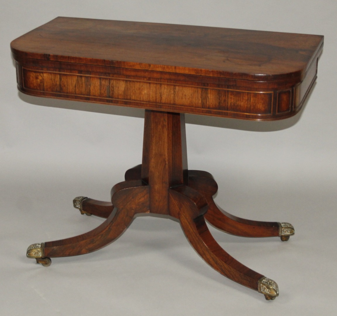 Appraisal: A Regency rosewood D-end games table the top hinging to