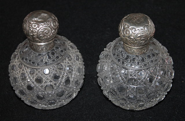 Appraisal: TWO CUT GLASS PERFUME BOTTLES of globular form with silver