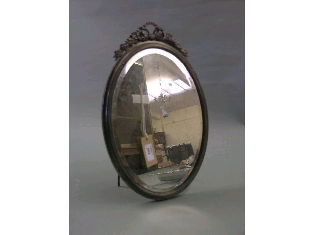 Appraisal: A silver plated dressing mirror oval shape with ribbon cresting