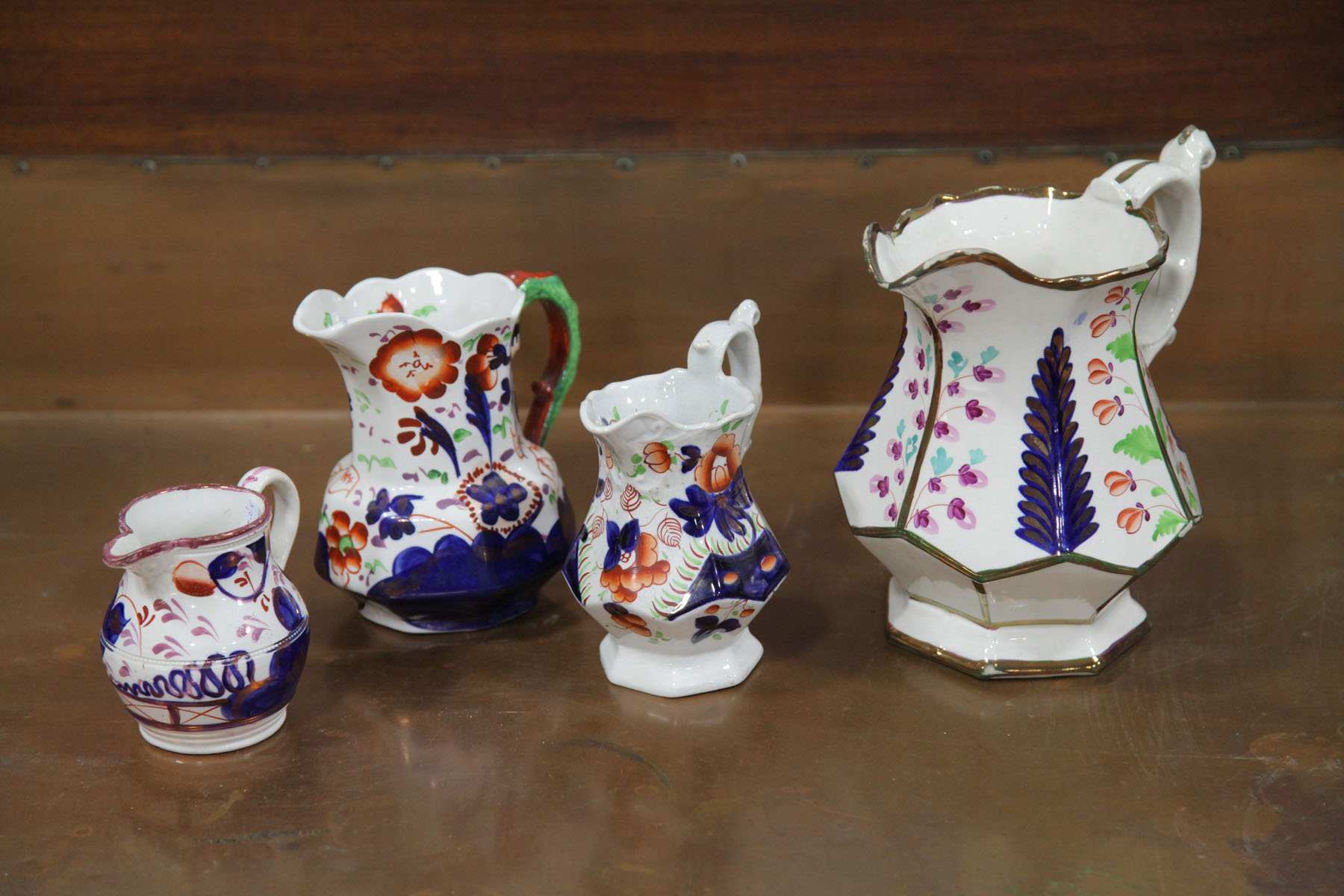 Appraisal: FOUR GAUDY IRONSTONE CHINA PITCHERS English mid to late th